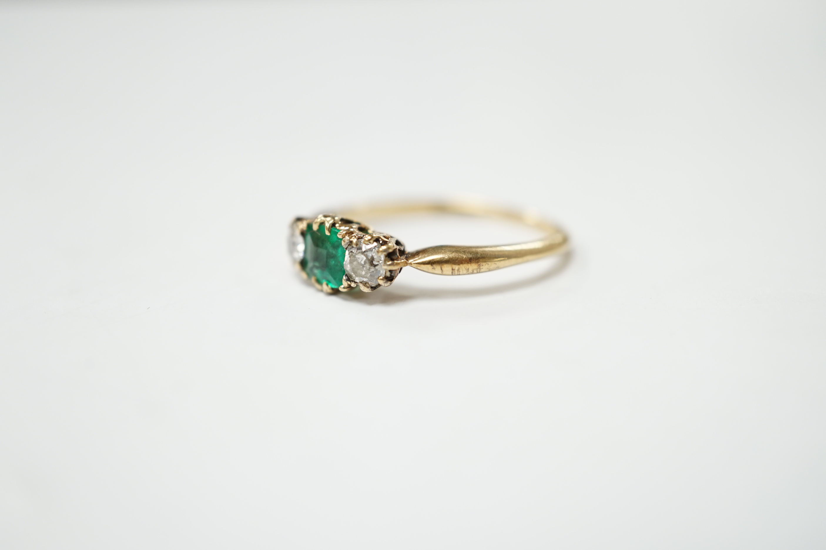 An early to mid 20th century 18ct, emerald and diamond set three stone ring, size O/P, gross weight 2.9 grams.